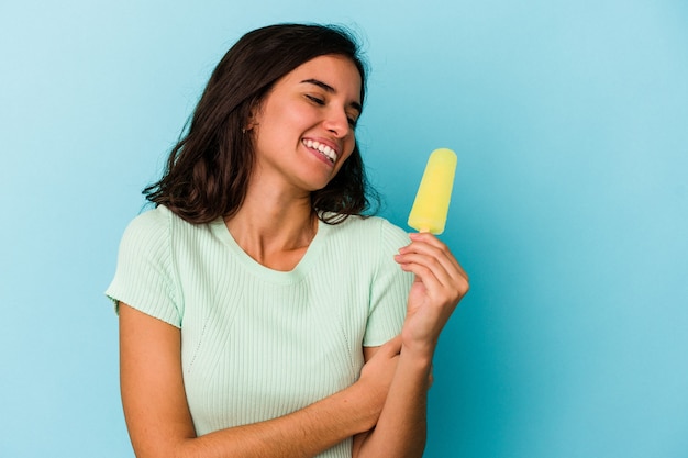 Junge kaukasische Frau mit einem Eis auf blauem Hintergrund isoliert isolated