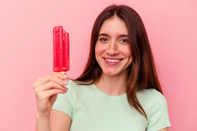 Junge kaukasische Frau mit einem Eis isoliert auf rosa Wand