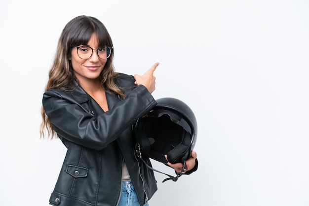 Junge kaukasische Frau mit einem Motorradhelm lokalisiert auf dem weißen Hintergrund, der zurück zeigt