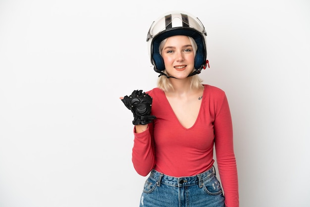 Junge kaukasische Frau mit einem Motorradhelm lokalisiert auf weißem Hintergrund, der auf die Seite zeigt, um ein Produkt zu präsentieren