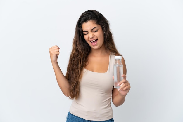 Junge kaukasische Frau mit einer Flasche Wasser isoliert auf weißem Hintergrund einen Sieg feiernd