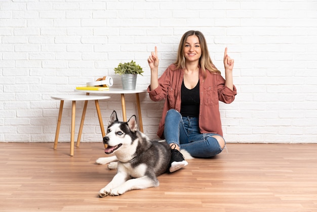 Junge kaukasische Frau mit Hund über isolierter Wand