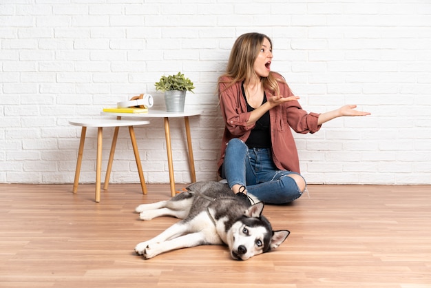 Junge kaukasische Frau mit Hund über isolierter Wand