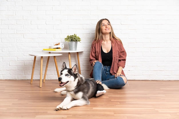 Junge kaukasische Frau mit ihrem Hund drinnen