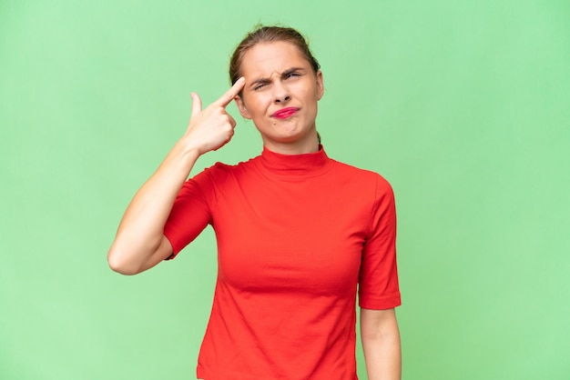 Junge kaukasische Frau mit isoliertem Hintergrund, die die Geste des Wahnsinns macht und den Finger auf den Kopf legt