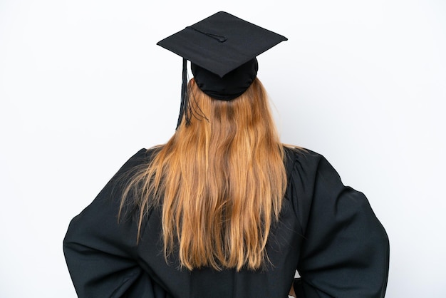 Junge kaukasische Frau mit Universitätsabschluss isoliert auf weißem Hintergrund in der hinteren Position