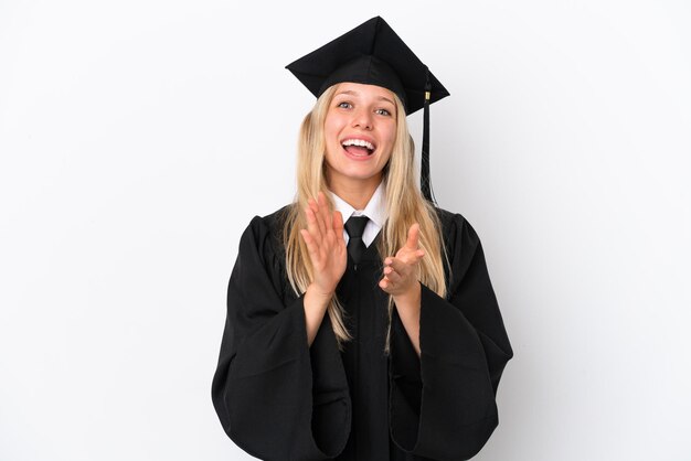 Junge kaukasische Frau mit Universitätsabsolvent isoliert auf weißem Hintergrund, die nach einer Präsentation auf einer Konferenz applaudiert