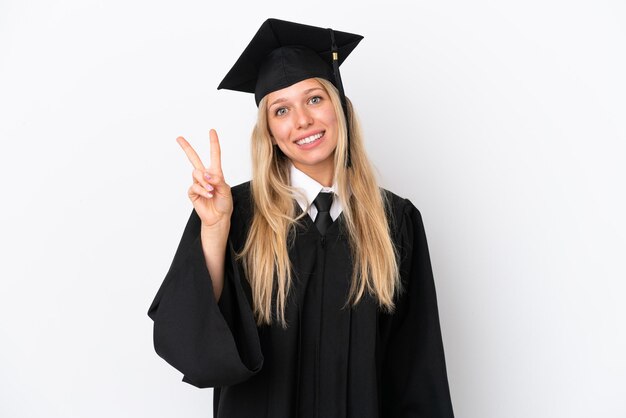 Junge kaukasische Frau mit Universitätsabsolvent, isoliert auf weißem Hintergrund, lächelt und zeigt Victory-Zeichen