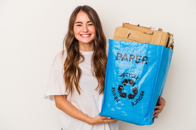 Junge kaukasische Frau Recyclingpapier isoliert auf weißem Hintergrund glücklich, lächelnd und fröhlich.
