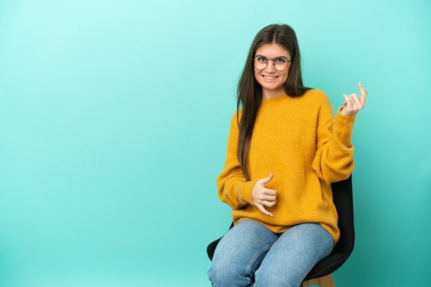 Junge kaukasische Frau sitzt auf einem Stuhl isoliert chair