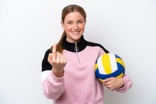 Junge kaukasische Frau spielt Volleyball isoliert auf weißem Hintergrund und macht kommende Geste