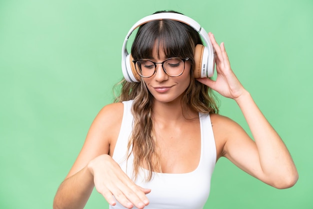 Junge kaukasische Frau über lokalisiertem Hintergrund, der Musik und Tanz hört