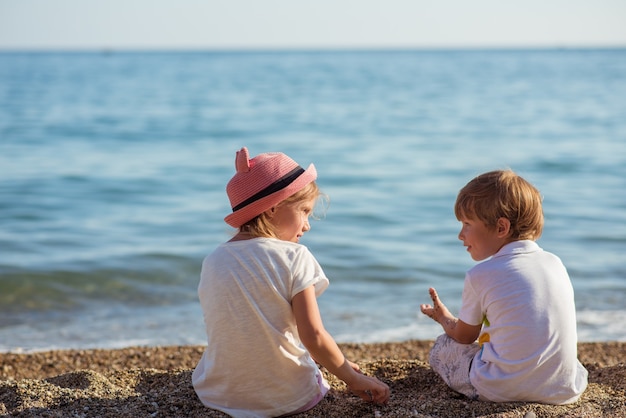 Junge kaukasische Kinder am Ozeanufer an einem sonnigen Sommertag