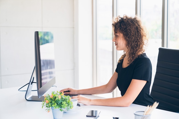 Foto junge kaukasische kreative arbeitskraft, die zu hause an computer im büro arbeitet