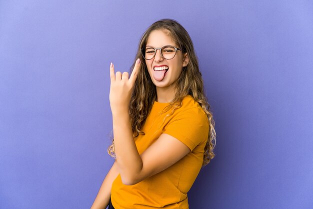 Junge kaukasische niedliche Frau, die Rockgeste mit den Fingern zeigt