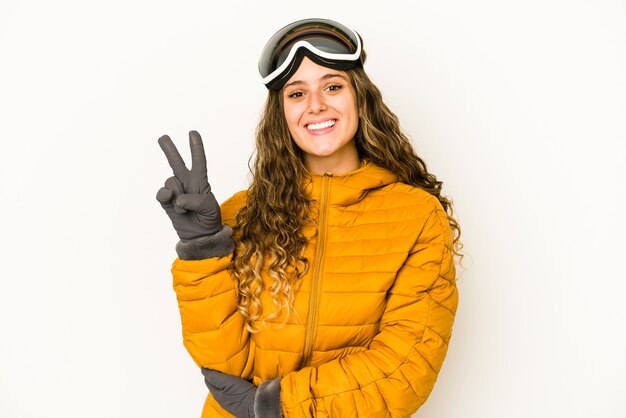 Junge kaukasische Snowboarderfrau lokalisiert, die Nummer zwei mit den Fingern zeigend.