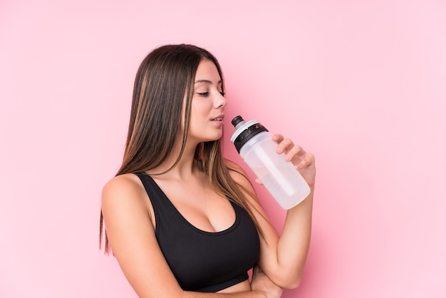 Junge kaukasische sportliche Frau, die eine Wasserflasche hält