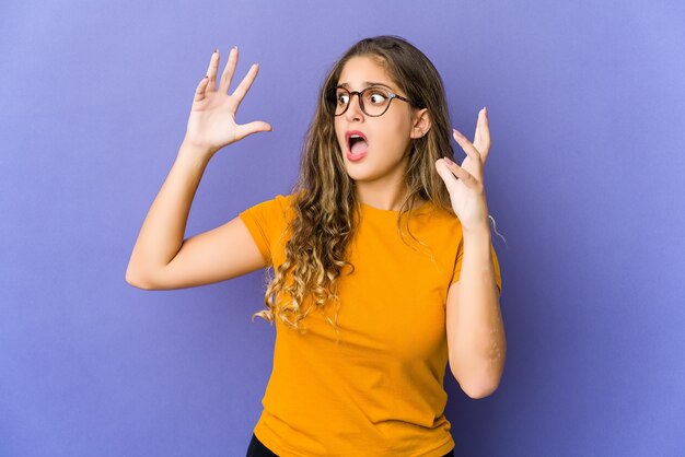 Junge kaukasische süße Frau, die zum Himmel schreit und aufschaut, frustriert.