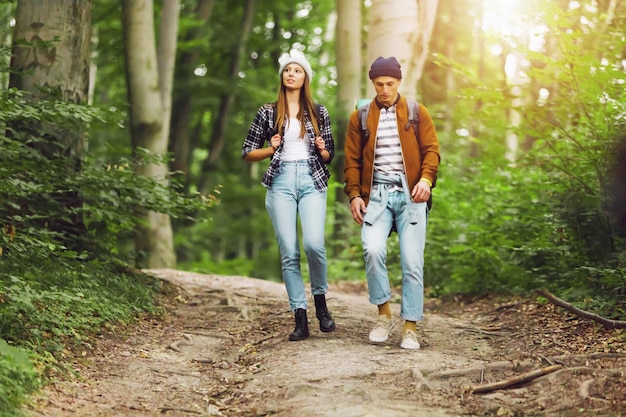 Junge kaukasische Wanderer mit Rucksäcken, die die Waldnatur genießen