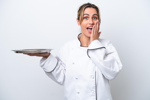Junge Köchin mit Tablett isoliert auf weißem Hintergrund mit überraschtem und schockiertem Gesichtsausdruck