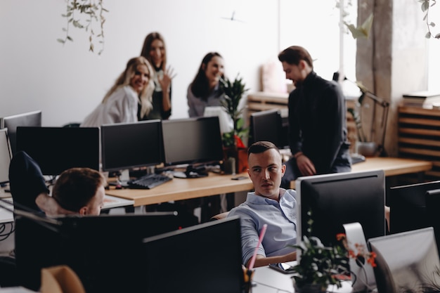 Junge Kollegen besprechen das Projekt in einem stilvollen modernen Büro. Arbeitsablauf im Büro.