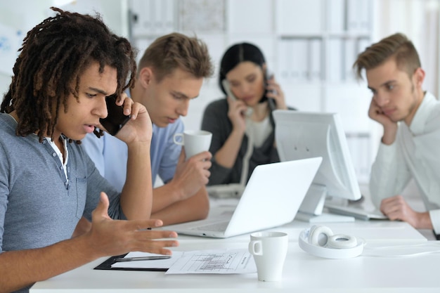 Foto junge kollegen im büro arbeiten zusammen