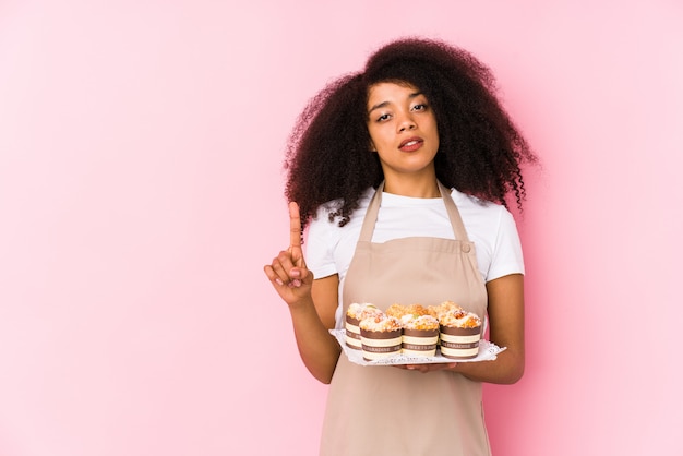 Junge Konditorfrau, halten kleine Kuchen