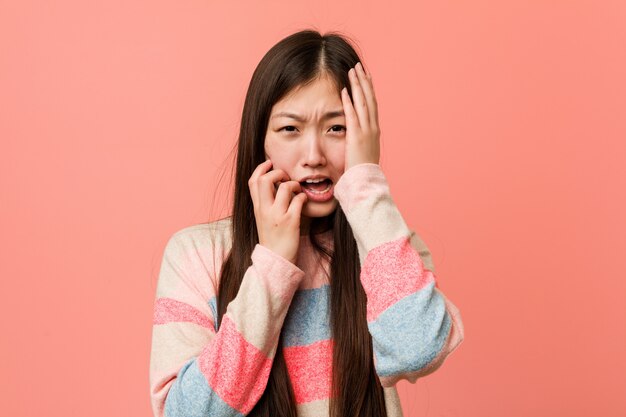 Junge kühle chinesische Frau, die trostlos jammert und schreit.