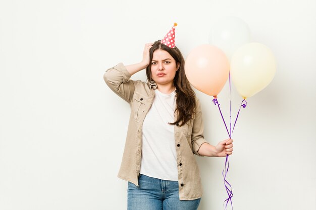 Junge kurvige Frau in Übergröße, die einen Geburtstag feiert, der schockiert ist, sie hat sich an wichtiges Treffen erinnert.