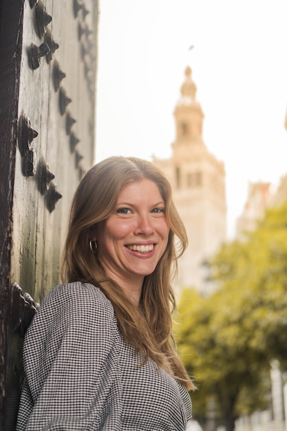 Junge lächelnde blonde Mädchen Blick in die Kamera mit der Kathedrale von Sevilla im Hintergrund in Sevilla?