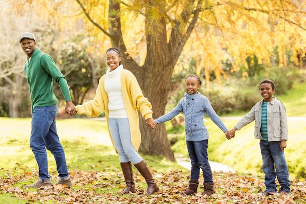 Junge lächelnde Familie, die ihre Hände anderen gibt