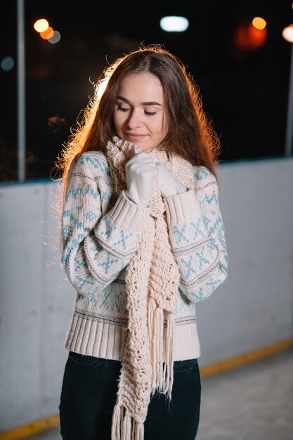 Foto junge lächelnde frau auf eisbahn