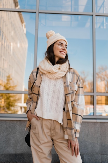 Foto junge lächelnde frau, die im winter auf der straße spazieren geht