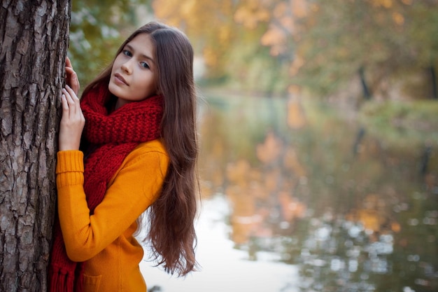 Junge lächelnde Frau im Herbstpark