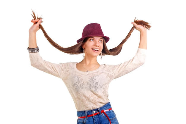 Foto junge lächelnde frau mit langen haaren in den händen und rotem hut