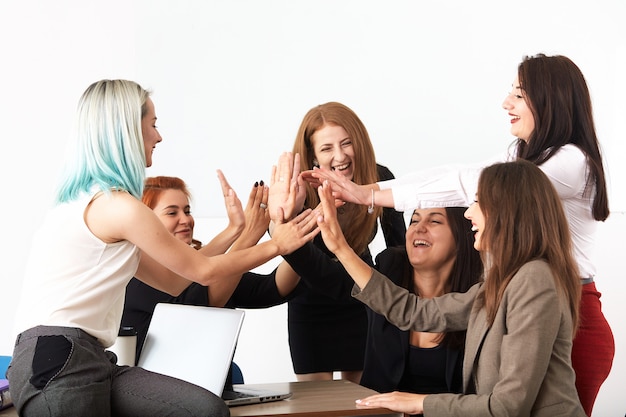 Junge lächelnde Geschäftsfrauen, die neues Projekt im Büro bearbeiten.