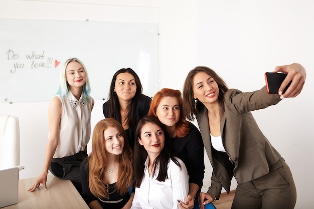 Junge lächelnde Geschäftsfrauen, die neues Projekt im Büro bearbeiten.