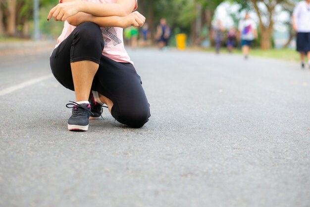 Junge Läuferfrau, die auf der Straße ruht.