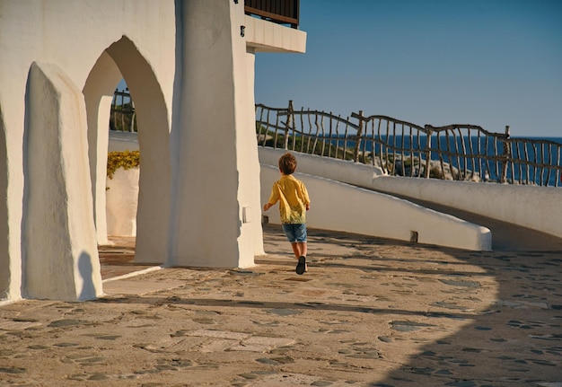 Junge läuft im Dorf am Meer