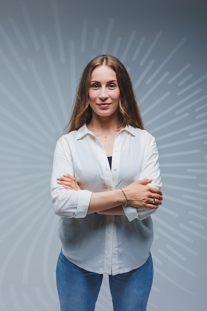 Junge langhaarige Frau in Jeans und einem weißen Hemd auf einem einfarbigen Hintergrund Emotionen auf dem Gesicht einer Frau