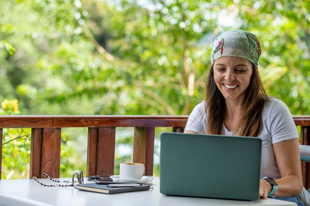 Junge lateinamerikanische Frau, die an ihrem Laptop in einem Straßencafé Panama arbeitet