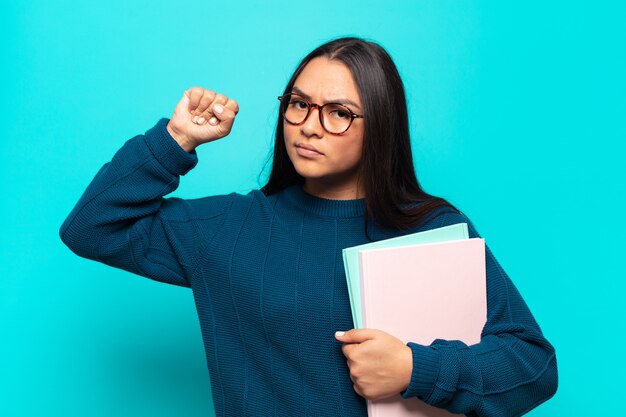 junge lateinamerikanische Frau, die sich ernst, stark und rebellisch fühlt, die Faust erhebt, protestiert oder für die Revolution kämpft