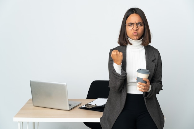 Junge lateinamerikanische Geschäftsfrau, die in einem Büro arbeitet, isoliert auf weißem Hintergrund mit unglücklichem Ausdruck isolated