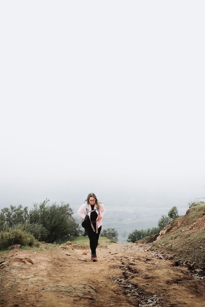 Junge lateinamerikanische Plus-Size-Frau mit Rucksack, Klettern auf einem Hügel und Wandern in einer wunderschönen Landschaft.