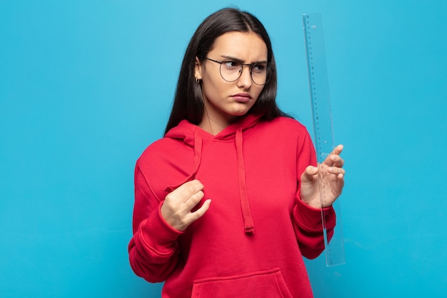 junge lateinische frau, die arrogant, erfolgreich, positiv und stolz aussieht und auf sich selbst zeigt