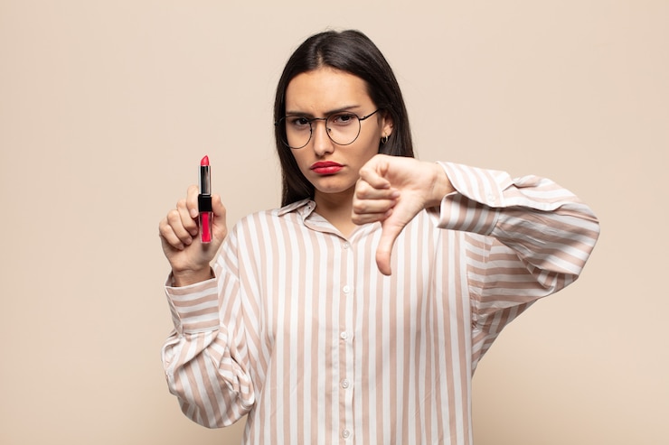Foto junge lateinische frau, die sich verärgert, wütend, verärgert, enttäuscht oder unzufrieden fühlt und mit ernstem blick daumen nach unten zeigt