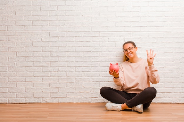 Junge lateinische Frau mit einem Sparschwein