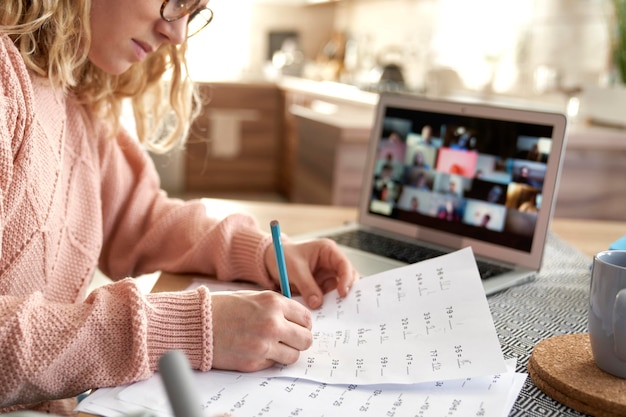 Junge Lehrerin bewertet Prüfungen während des Online-Kurses