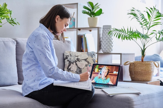 Junge Lehrerin hält Videokonferenz für ein Mädchen, das zu Hause sitzt