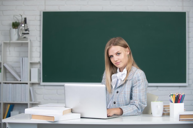 Junge Lehrerin, Studentin, die an einem Laptop im Klassenzimmer arbeitet und sich auf eine Prüfung vorbereitet